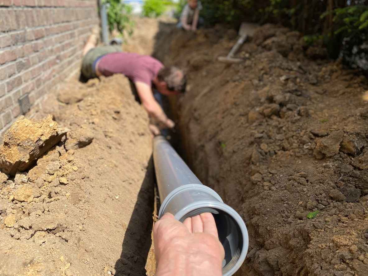 a man in the dirt replacing a residential sewer