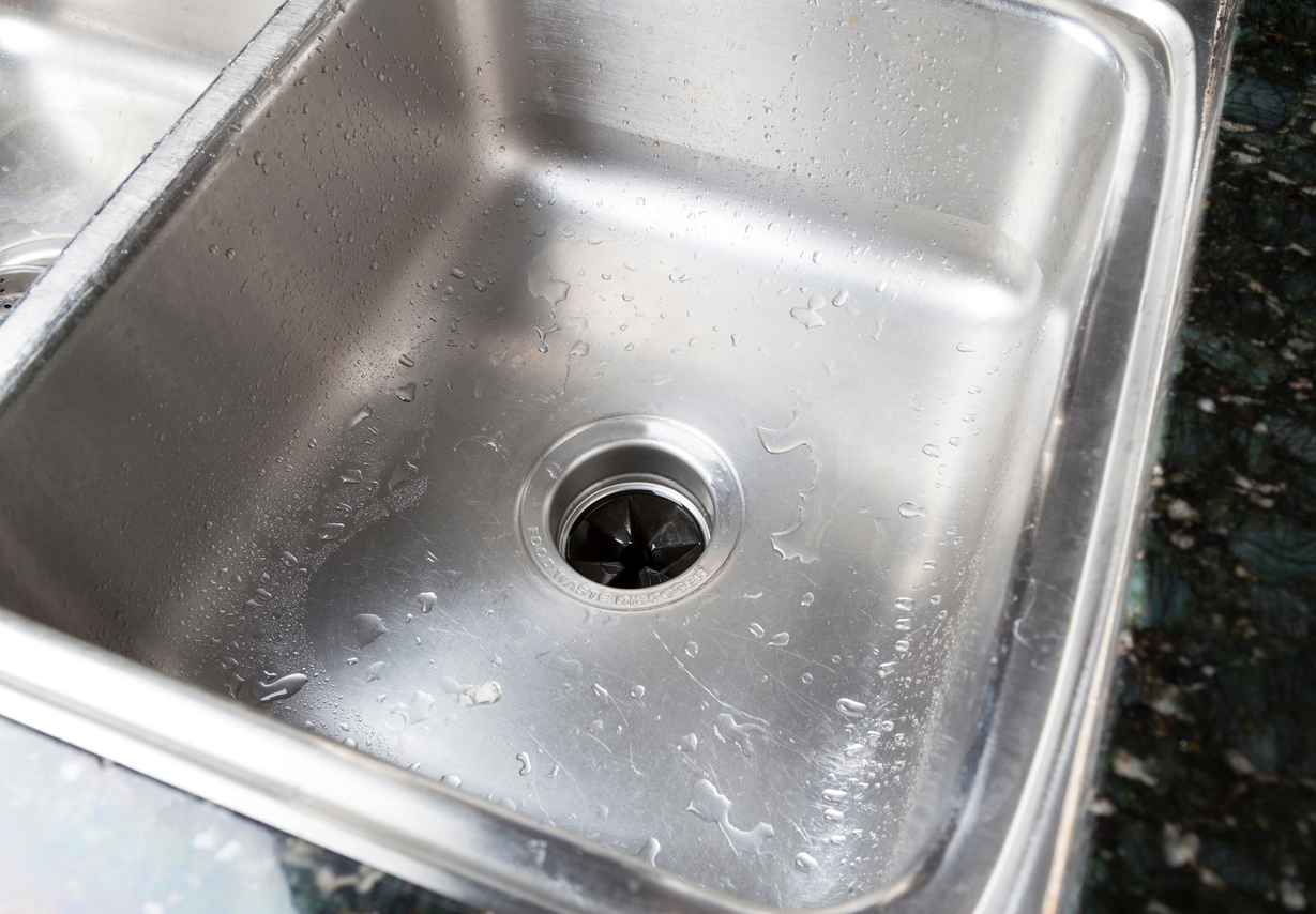 Stainless steel kitchen sink with garbage disposal.
