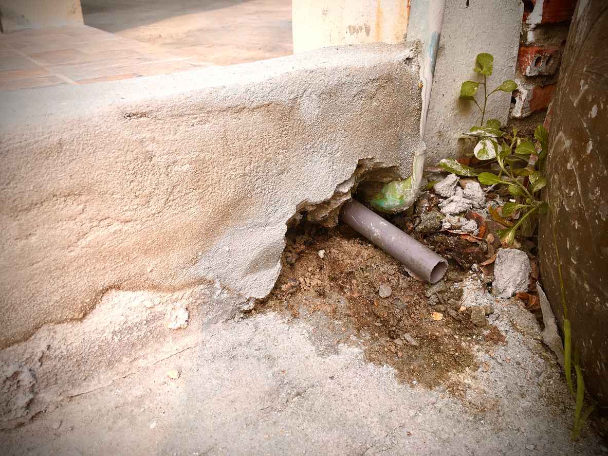 Air conditioner drain pipe or condensate line removing water from air conditioner on the floor